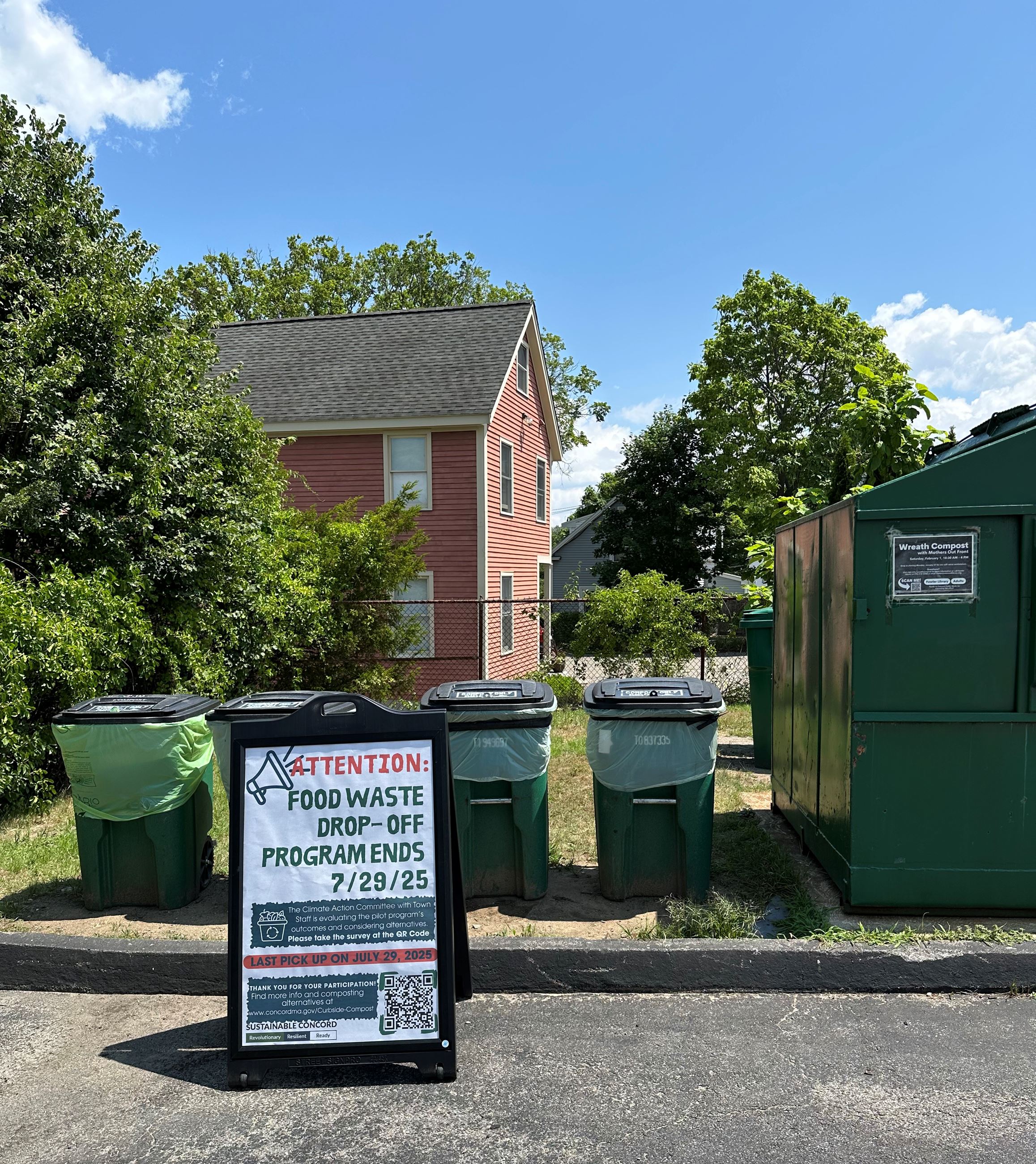 Sign board in front of 3 green barrels - Compost drop off ends on 7/29/25